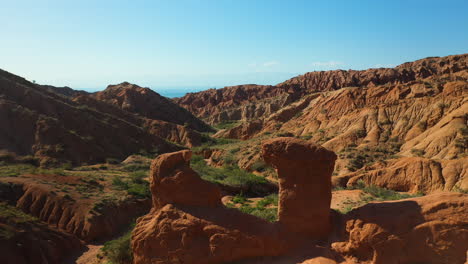 cinematic aerial shot flying through mountain valley at fairy tale canyon near issyk-kul lake in karakol, kyrgyzstan