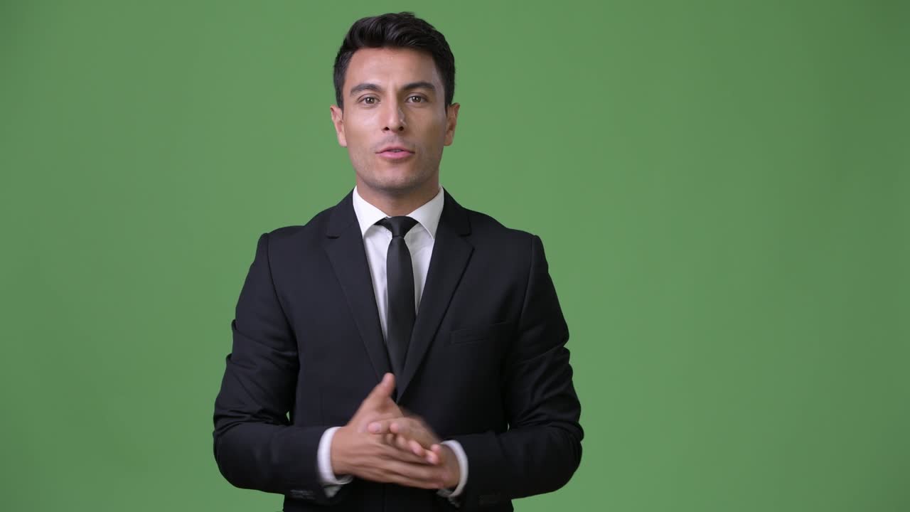 초록색 배경에 젊은 잘생긴 히스패닉 사업가