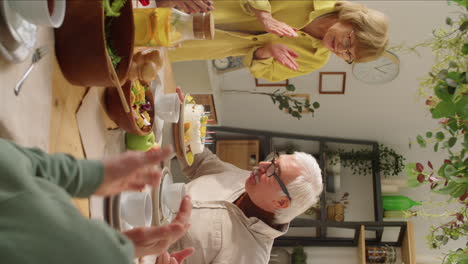 senior man blowing candles on birthday cake and kissing wife