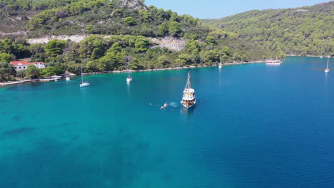 barco turístico amarrado en aguas tropicales, turistas nadando en el mar, revelación aérea