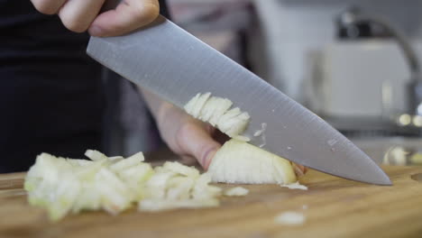 ripresa al rallentatore mentre si affetta una cipolla in piccoli pezzi su un tagliere, dieta dimagrante con verdure