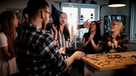 happy birthday girl reacts at sparkling firework cake at surprise celebration party with multiethnic friends slow motion