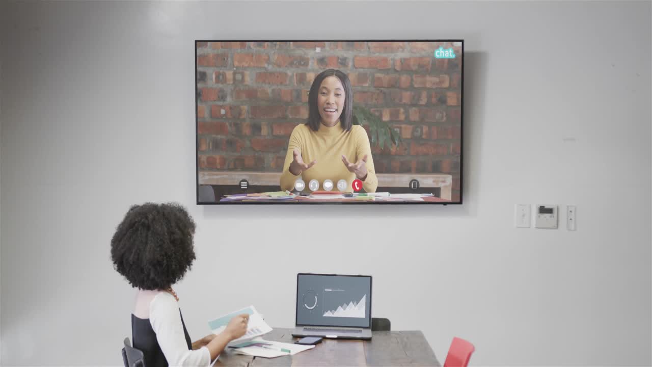 아프리카계 미국인 사업가 여성이 화면에서 아프리카계 미국인 여성 동료와 비디오 통화를 하고 있습니다.