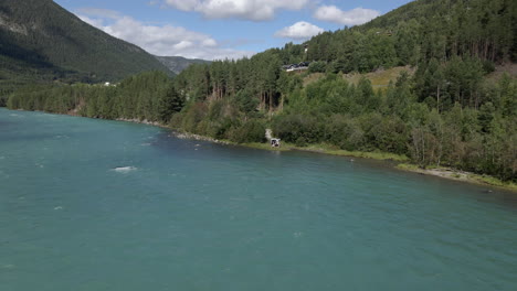 Aerial-drone-backward-moving-shot-over-Otta-river-in-Lom,-Norway-on-a-cloudy-day