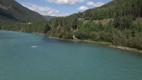 dron aéreo en movimiento hacia atrás sobre el río otta en lom, noruega en un día nublado