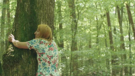 una mujer abraza un árbol en el bosque.