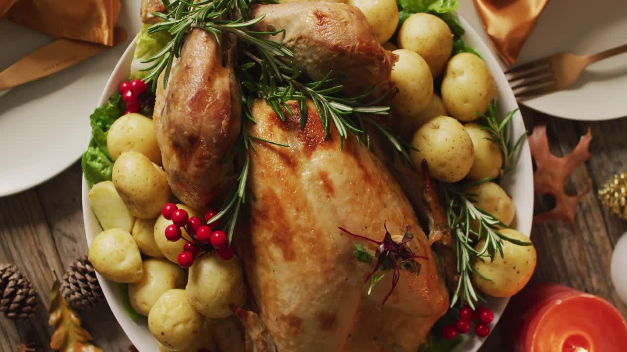 video de bandeja con pavo asado y diversos platos en superficie de madera