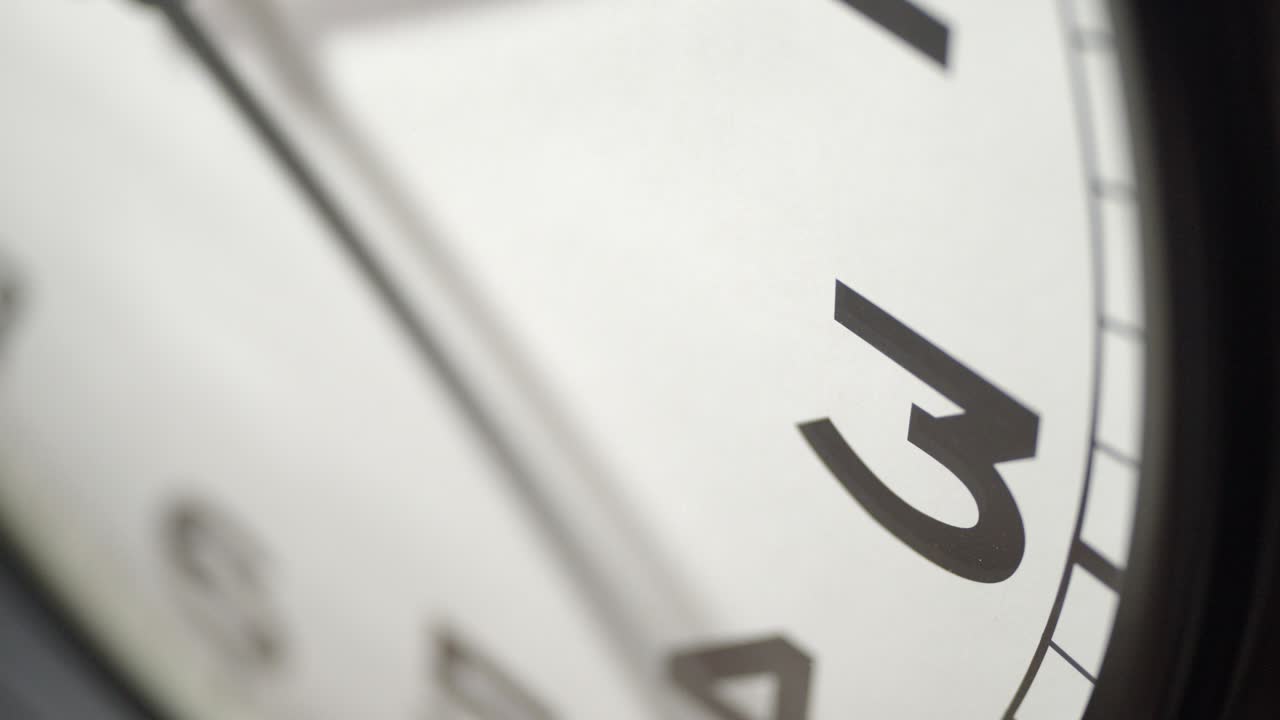 White Clock Face Close Up in Time Lapse on Dark Grey Wall