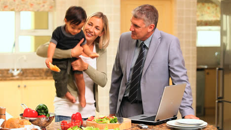 Doting-parents-trying-to-entertain-baby-in-kitchen