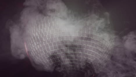 bola de discoteca girando y humo