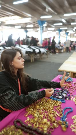 young woman browsing jewelry at a flea market