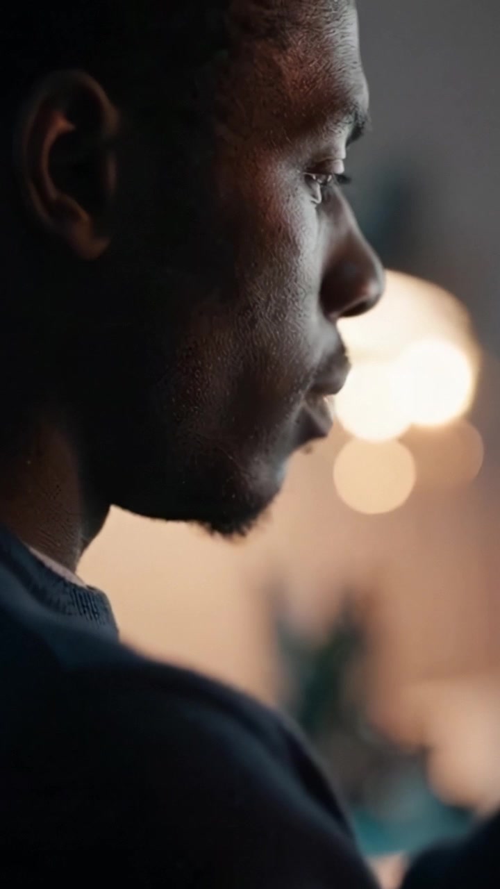 A Focused Individual Engaged in Thoughtful Reflection While Using a Mobile Device at Night, Capturing Intense Concentration and Contemplation in Soft Lighting