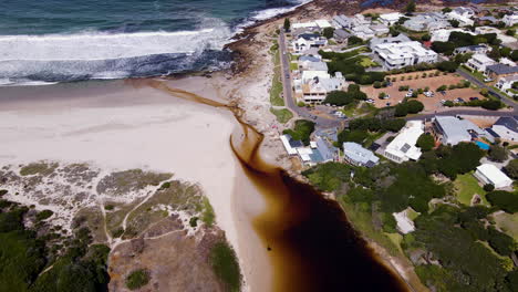 Scenic-setting-of-coastal-town-on-lagoonside-and-white-sandy-beach,-Onrus