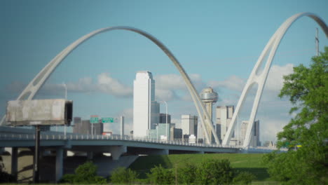 slow zoom-in - the dallas skyline is framed by the margaret mcdermott bridge with the iconic reunion tower in the center
