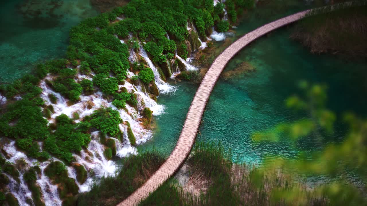 Scenic natural landscape with turquoise water, waterfall, wooden path. Plitvice Lakes National Park