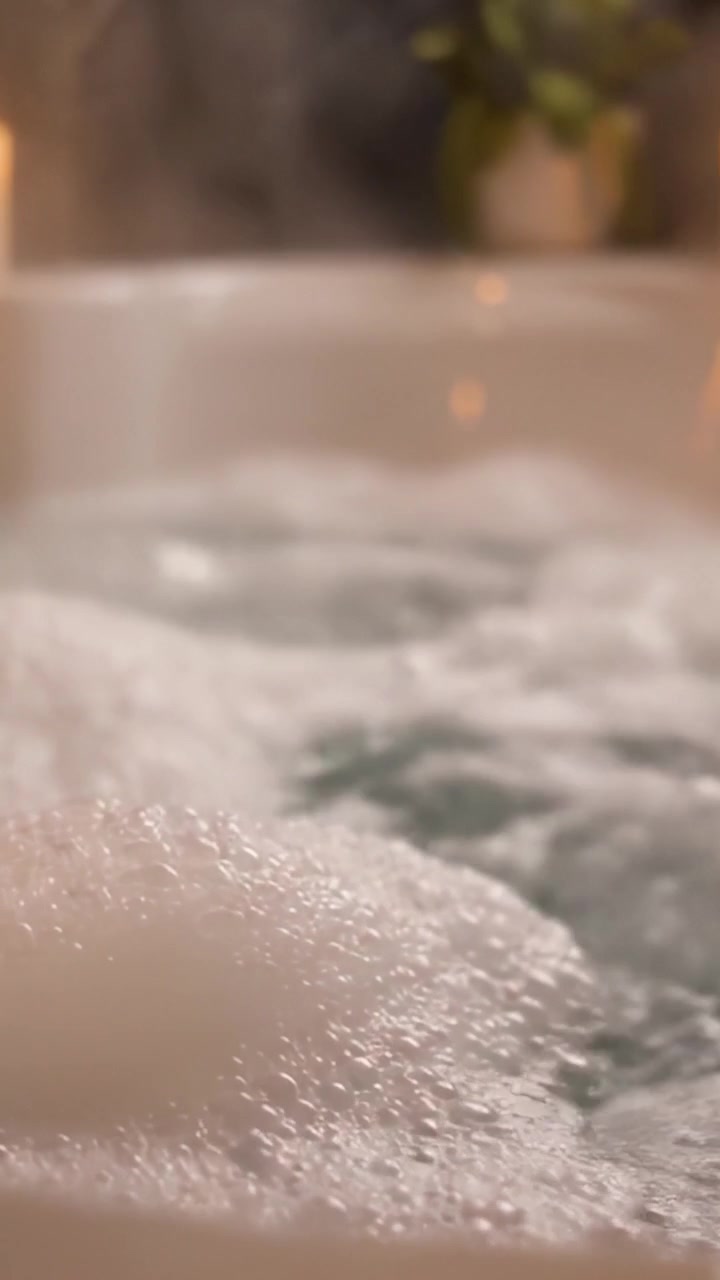 A Serene Escape: Embrace Relaxation and Comfort in a Bubbling Bathtub Filled with Soothing Water and Lush Greenery for Perfect Self-Care Moments