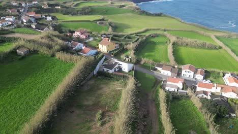 Vista-Aérea-De-Casas-Ubicadas-En-Medio-De-Exuberantes-Campos-Verdes-Bajo-El-Sol-En-Las-Azores