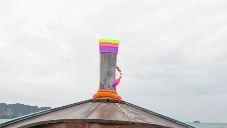 longtail boat bow decorated with colorful ribbons