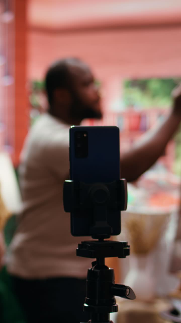 Smartphone på stativ optager kunstnere, der maler i studie