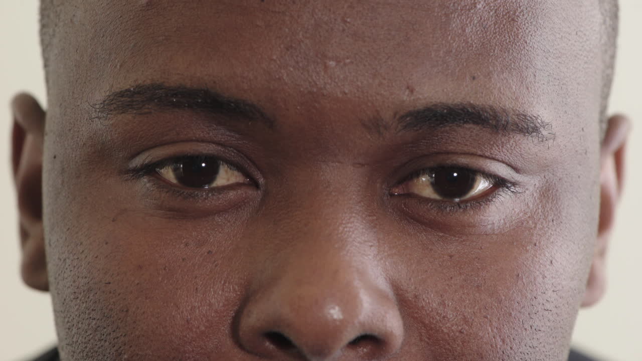 close up young african american man eyes looking pensive contemplative staring at camera eyesight health