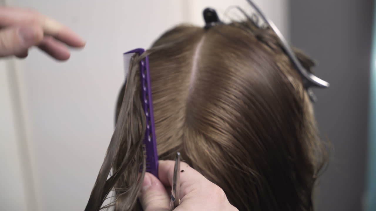 Hairdresser cutting hair of her customer at the hairdressing salon