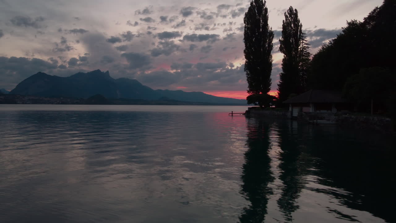 Vista aerea di case sulla riva del lago di Thun al tramonto.