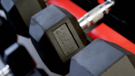 dumbbells on a rack in fitness studio 4k