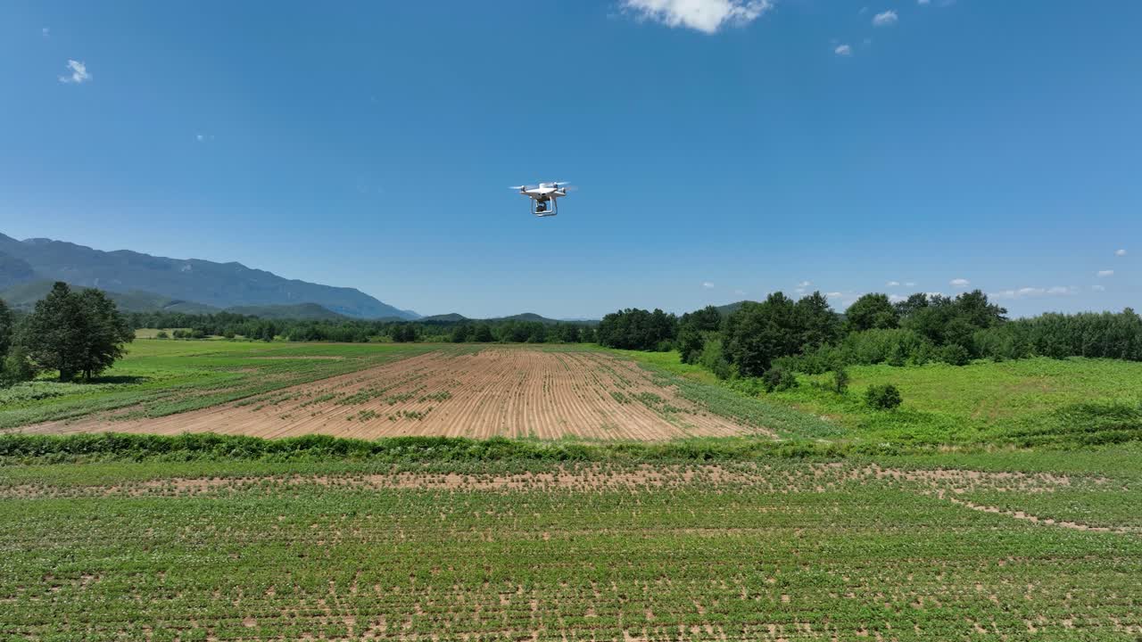 Drone flying over a green agricultural field for crop monitoring and precision mapping
