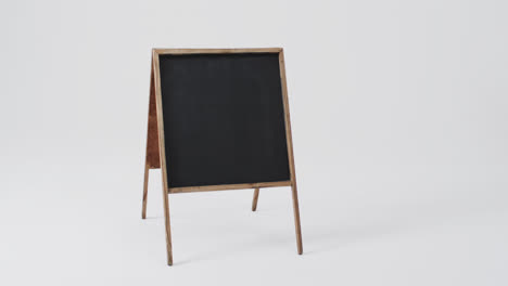 Video-of-blackboard-sign-on-wooden-stand-with-copy-space-on-white-background