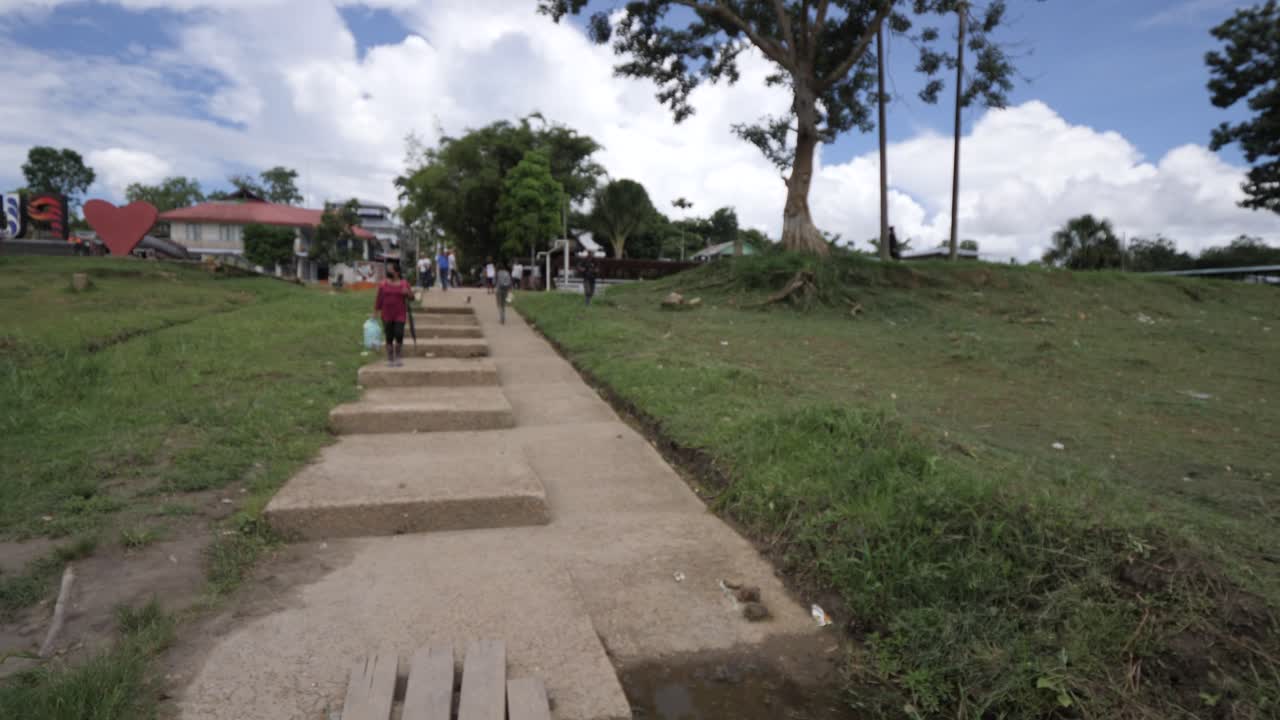 People cross a simple wooden bridge on the Amazon river