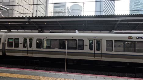 train leaving the station amidst city buildings