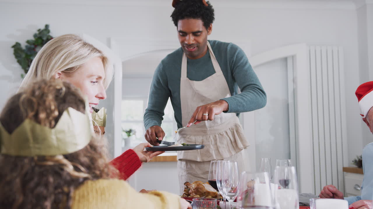 padre sirviendo comida en una familia multigeneracional comida de navidad en casa