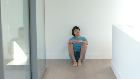 teenage asian boy sits alone indoors, with copy space