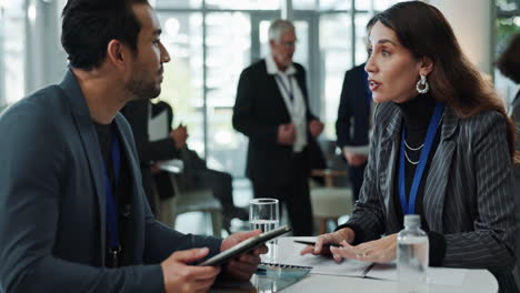 two business professionals have a conversation at a conference