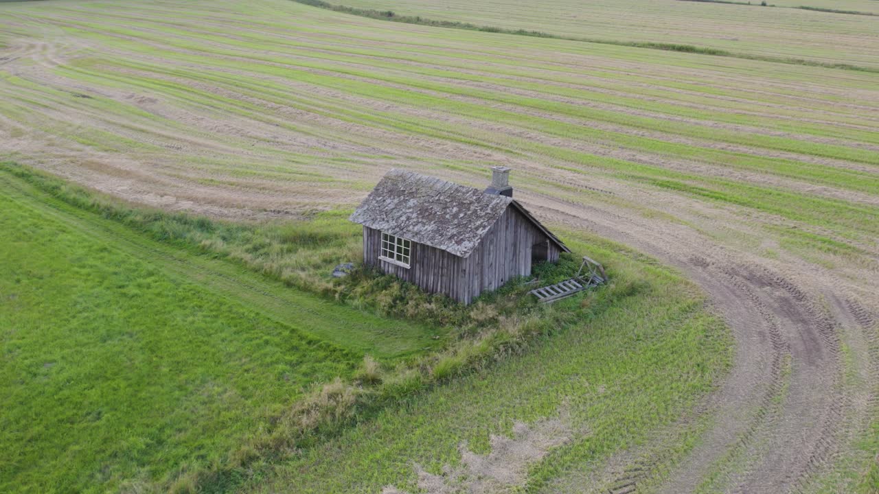 Old rustic blacksmith workshop standing alone in a green field in Sweden