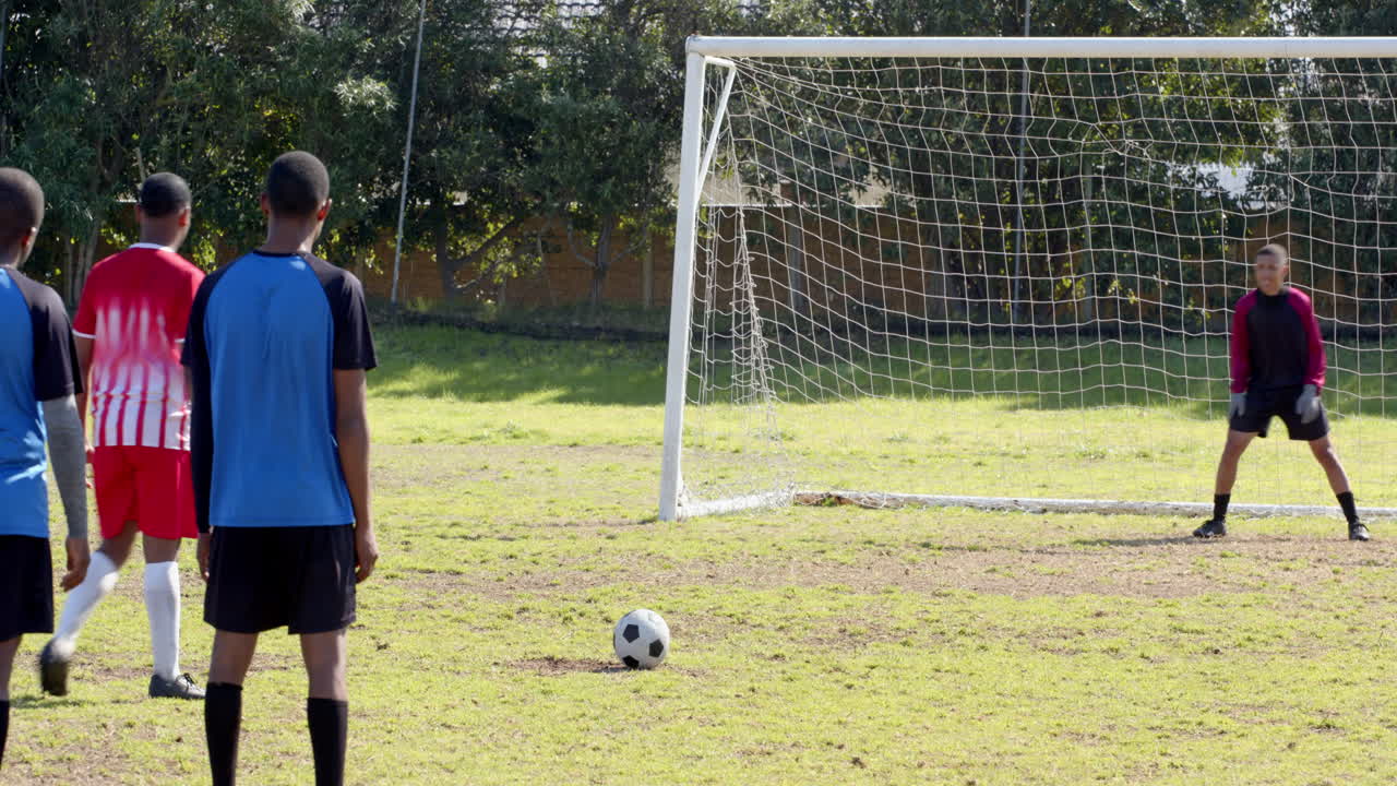Playing soccer, player preparing to take penalty kick while goalkeeper waits