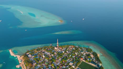 a stunning aerial drone view showcasing rasdhoo island surrounded by crystal-clear turquoise waters and vibrant coral reefs in the maldives.