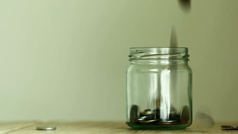 close up money coin falling into glass jar , a money saving , donation or business financial growth concept , 4k dci resolution , vintage retro color tone