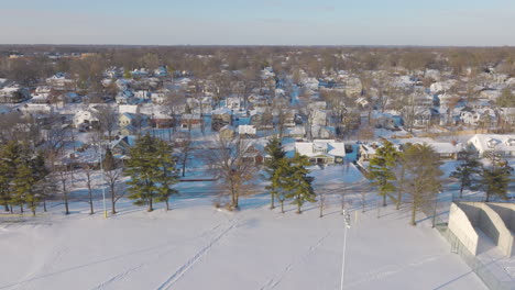 Pull-back-away-from-Kirkwood-neighborhood-and-over-park-with-fresh-fallen-snow-on-a-cold-winter-day-in-St