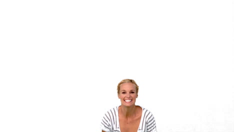 mujer rubia saltando contra un fondo blanco