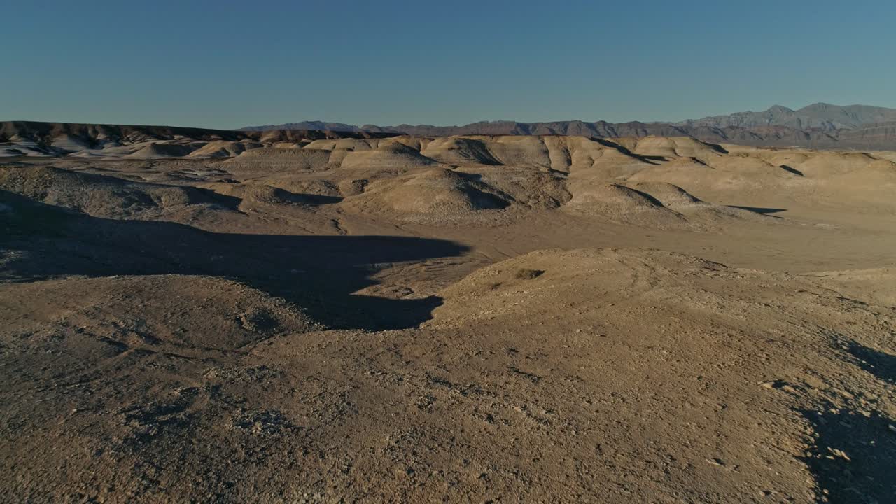 사막의 건조하고 황량한 이암 제방 위로 이동하는 느린 공중 전망