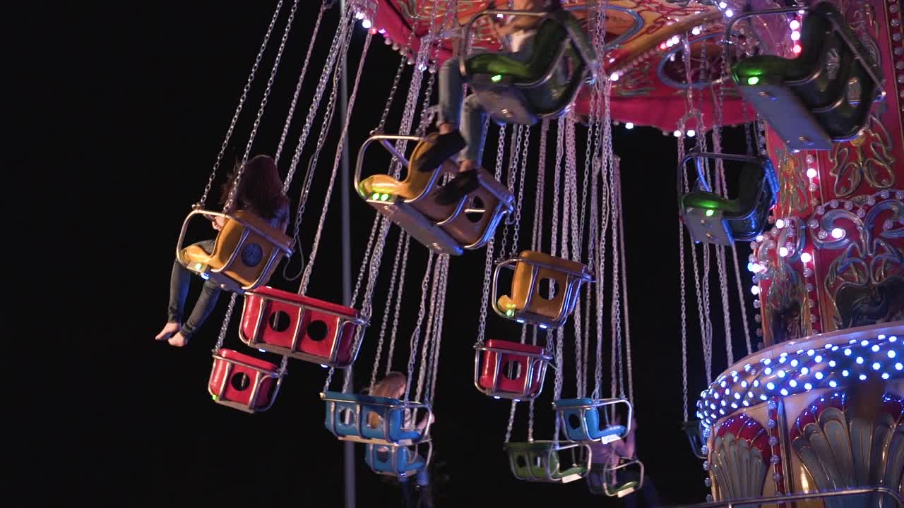 Colorful carousel at night in a park in slow motion