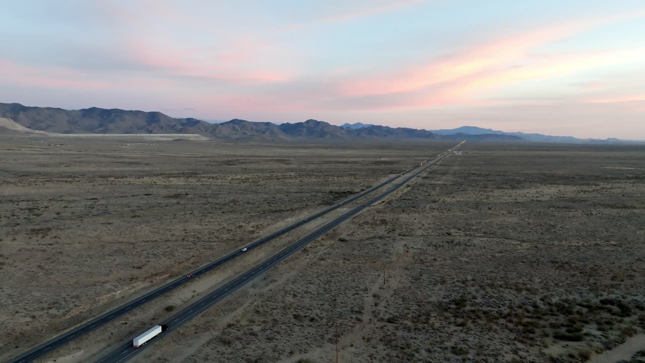 Highway 93 in Arizona with desert landscape and mountains in the distance with drone video moving in and down