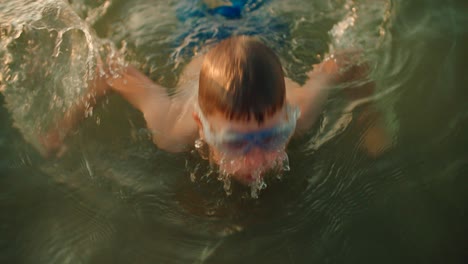 kid diving in water slow motion video