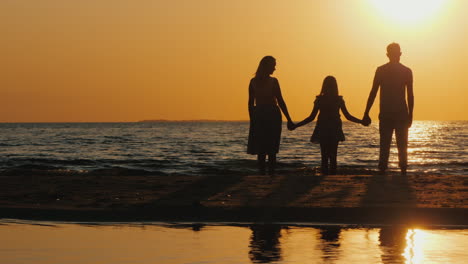 Eine-Junge-Familie-Mit-Kind-Kuschelt-Und-Freut-Sich-Auf-Den-Sonnenuntergang-über-Dem-Meer-Schöne-Gemeinsame-Zeit