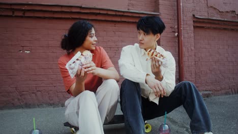 couple eating hot dogs on a skateboard