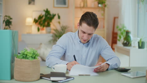 man works at desk with bills