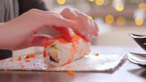 making sushi at home kitchen. woman hands rolling homemade sushi.