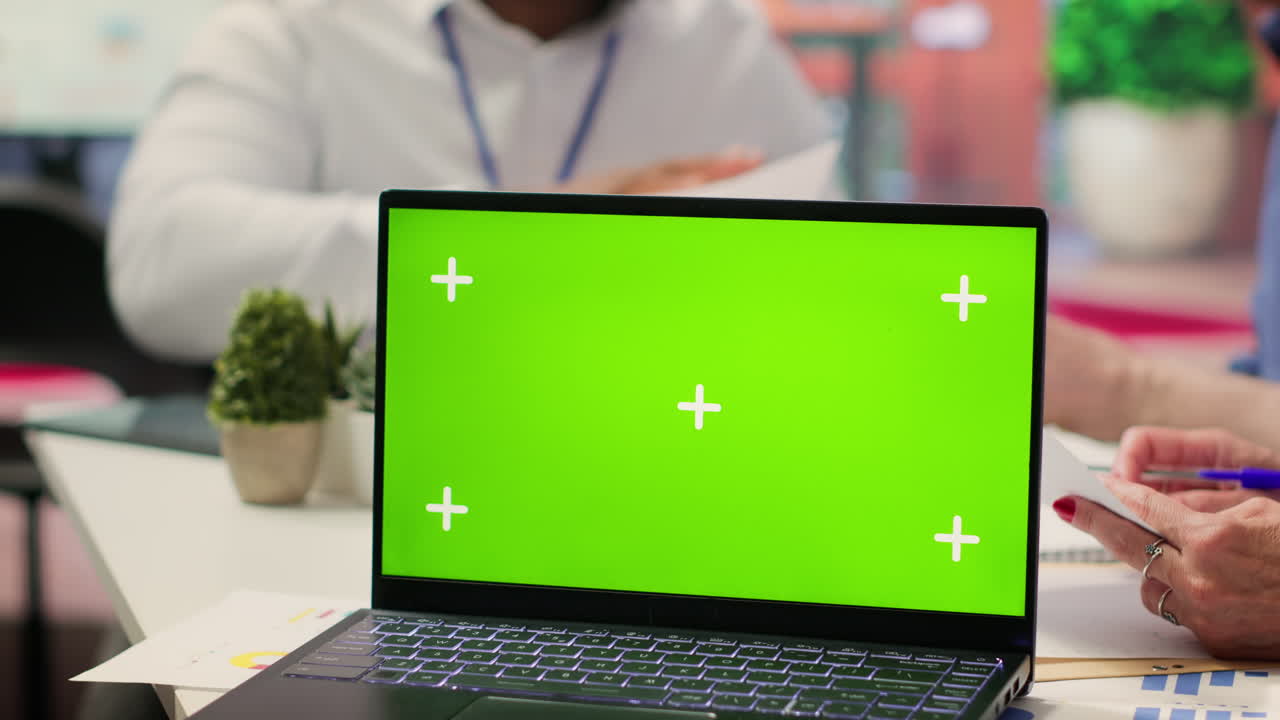 una pareja de ancianos explora la opción de jubilación financiera con un asesor junto a la pantalla verde.