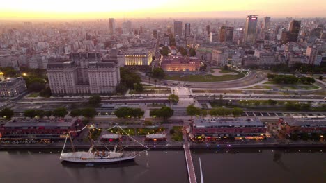 órbita-Aérea-Estableciendo-Una-épica-Toma-De-La-Hora-Del-Atardecer-Con-Los-Muelles-De-Puerto-Madero-Y-El-Barco-Museo-Fragata-A